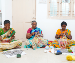 Women knitting colorful yarn together.