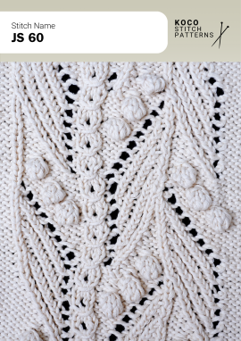 Scattered bobble accents and flowing cables create a richly textured, ornamental knit design Close-up of the JS 60 handknit stitch pattern in white yarn, featuring raised bobbles, flowing cable columns, and eyelet lace details
